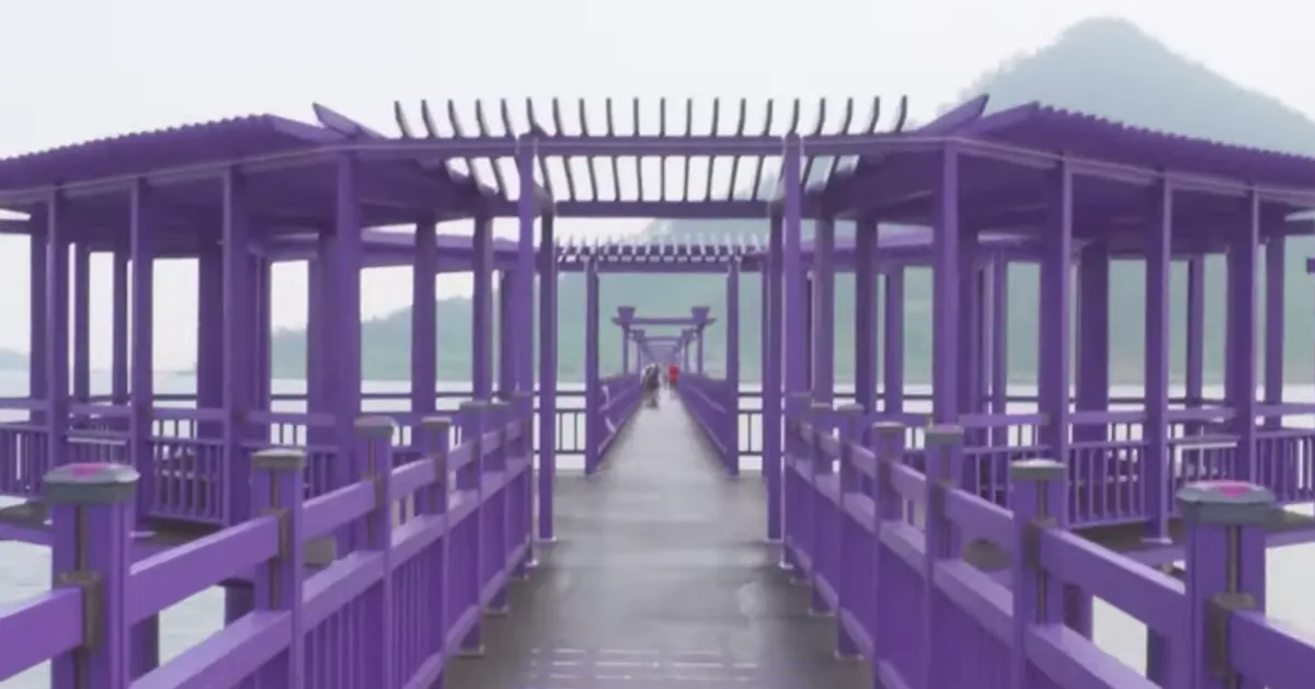 紫色的木質橋梁結構延伸在兩座山之間，呈現出獨特而和平的風景。