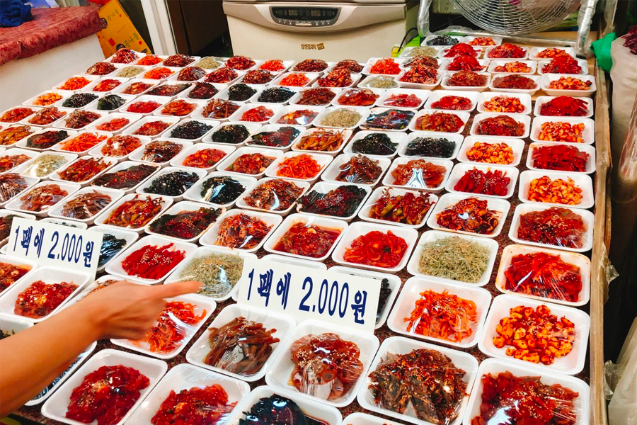 청량리 전통시장에서 신선하게 포장된 다양한 반찬류가 진열되어 있음.