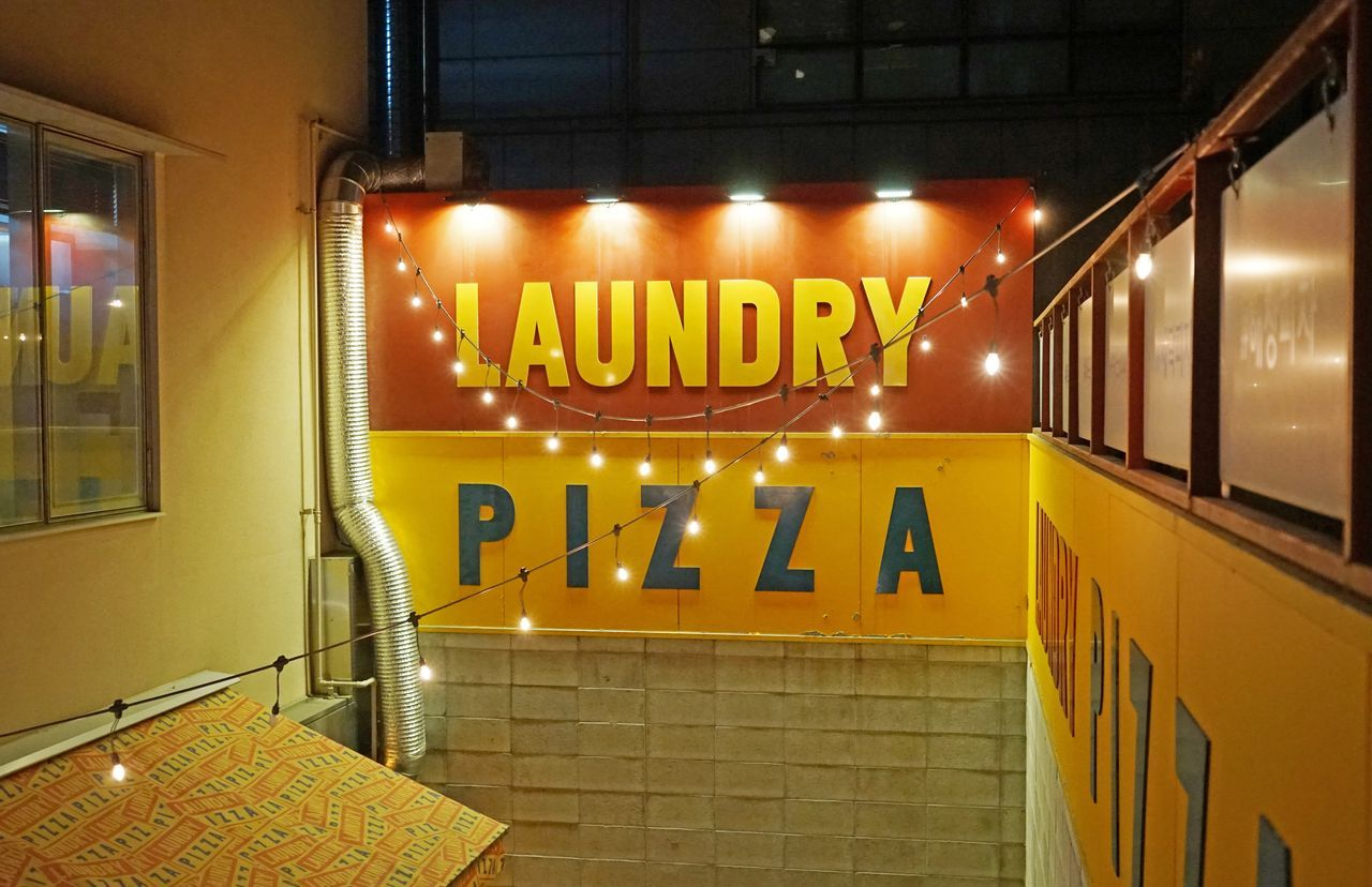 การตกแต่งบริเวณภายในร้าน Laundry Pizza ที่มีภาพถ่ายไอดอลมากมาย