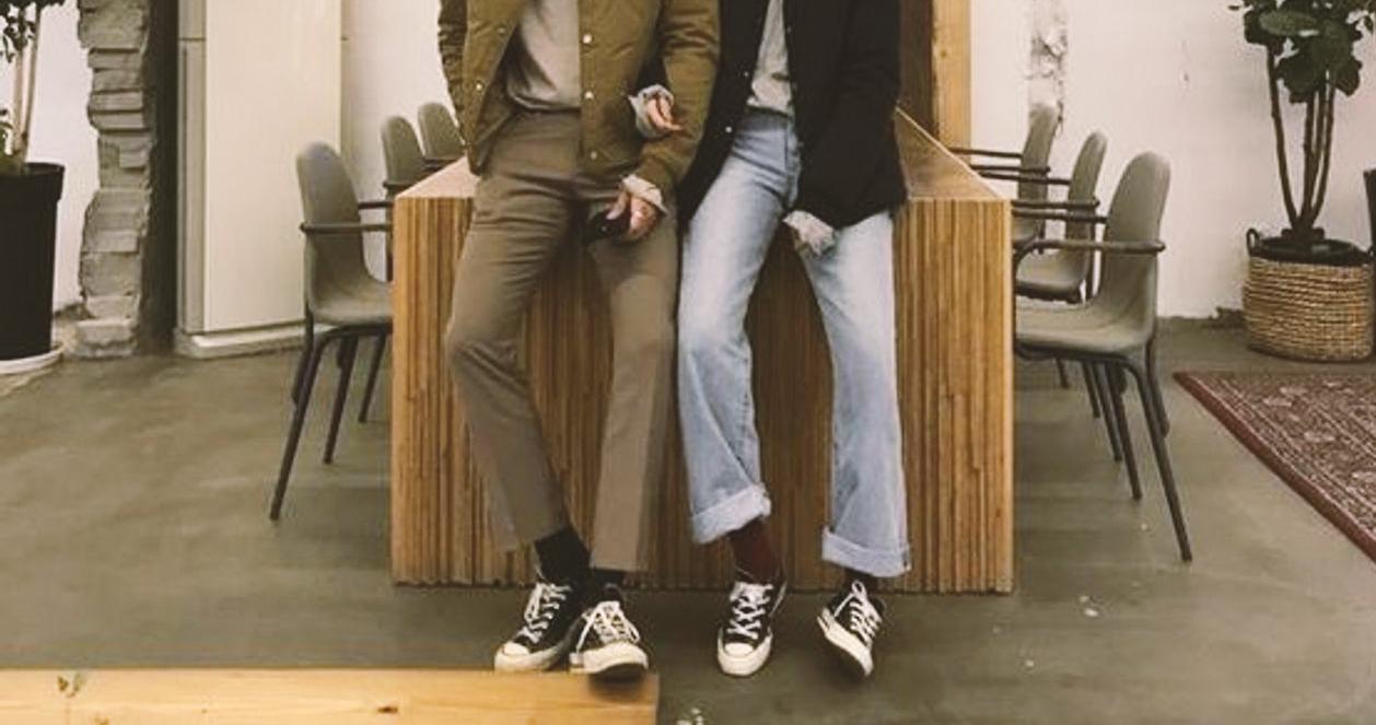 Cặp đôi Hàn Quốc đeo giày đôi Converse Chuck Taylor màu đen, thể hiện phong cách Hàn Quốc độc đáo.