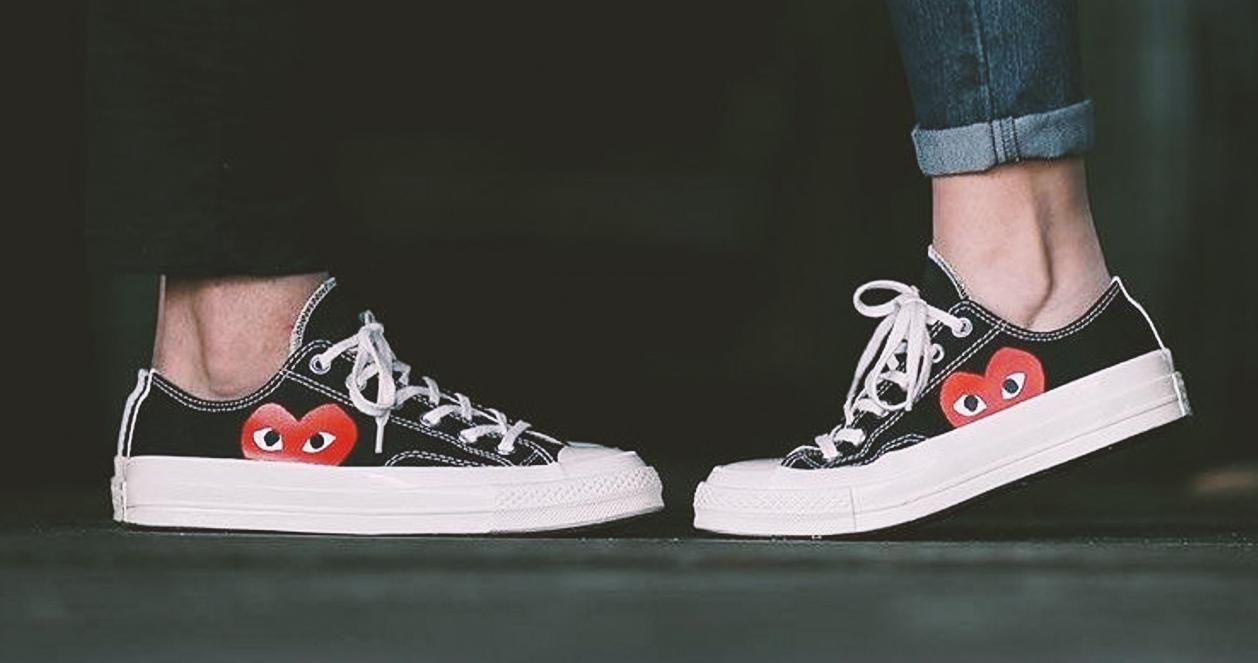 Cặp đôi mang giày Converse x Comme Des Garcons, nổi bật với biểu tượng trái tim đặc trưng.