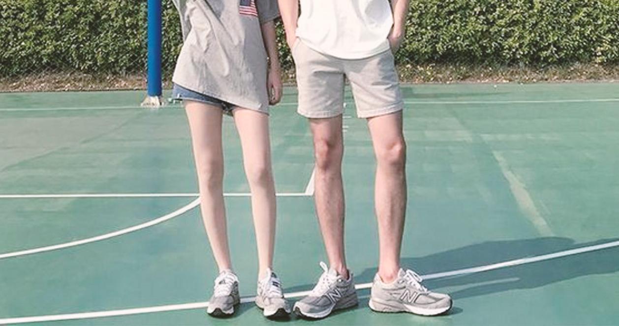 Cặp đôi đeo giày New Balance M990GL5, nổi bật trên sân bóng rổ ở Hàn Quốc, thể hiện phong cách thể thao.