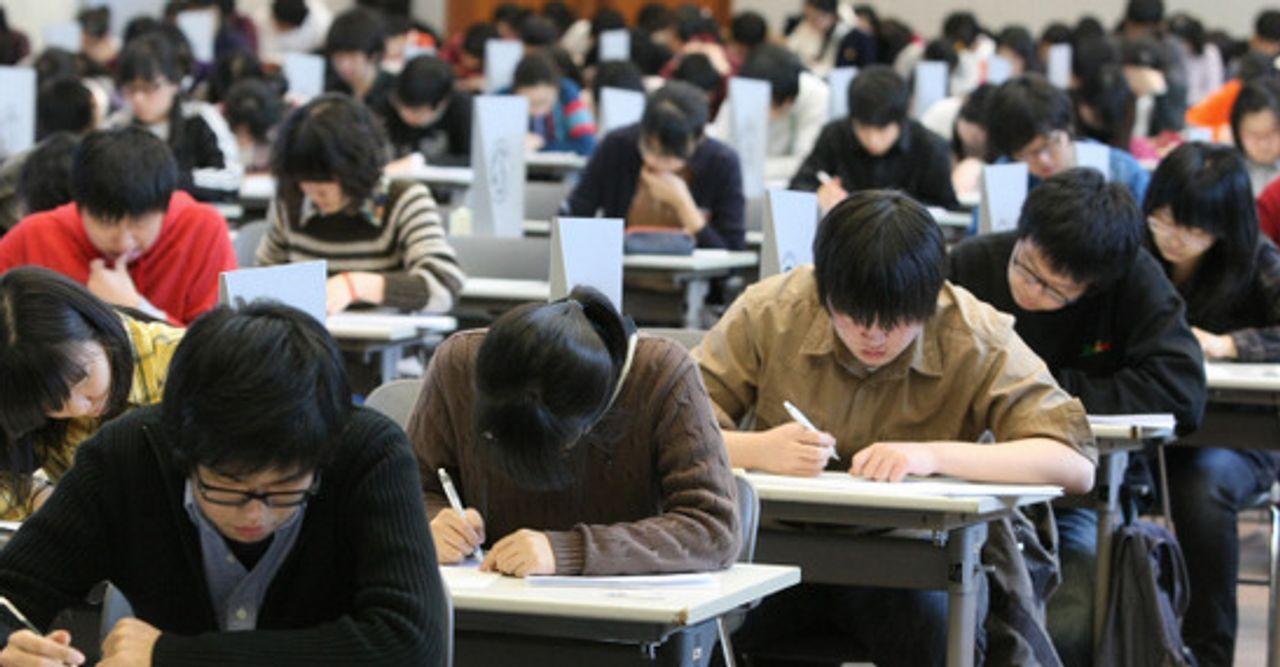 韓國疫情影響下，中學生遵循規則坐在教室中，準備考試。