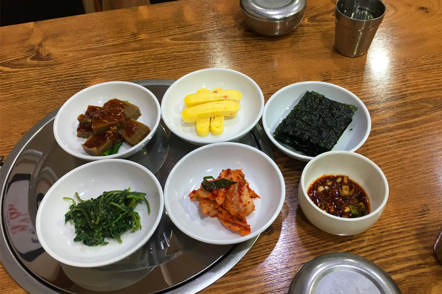 齋洞嫩豆腐的各式開胃小菜，包括泡菜、蛋卷、海苔等，組成豐富的開胃組合。