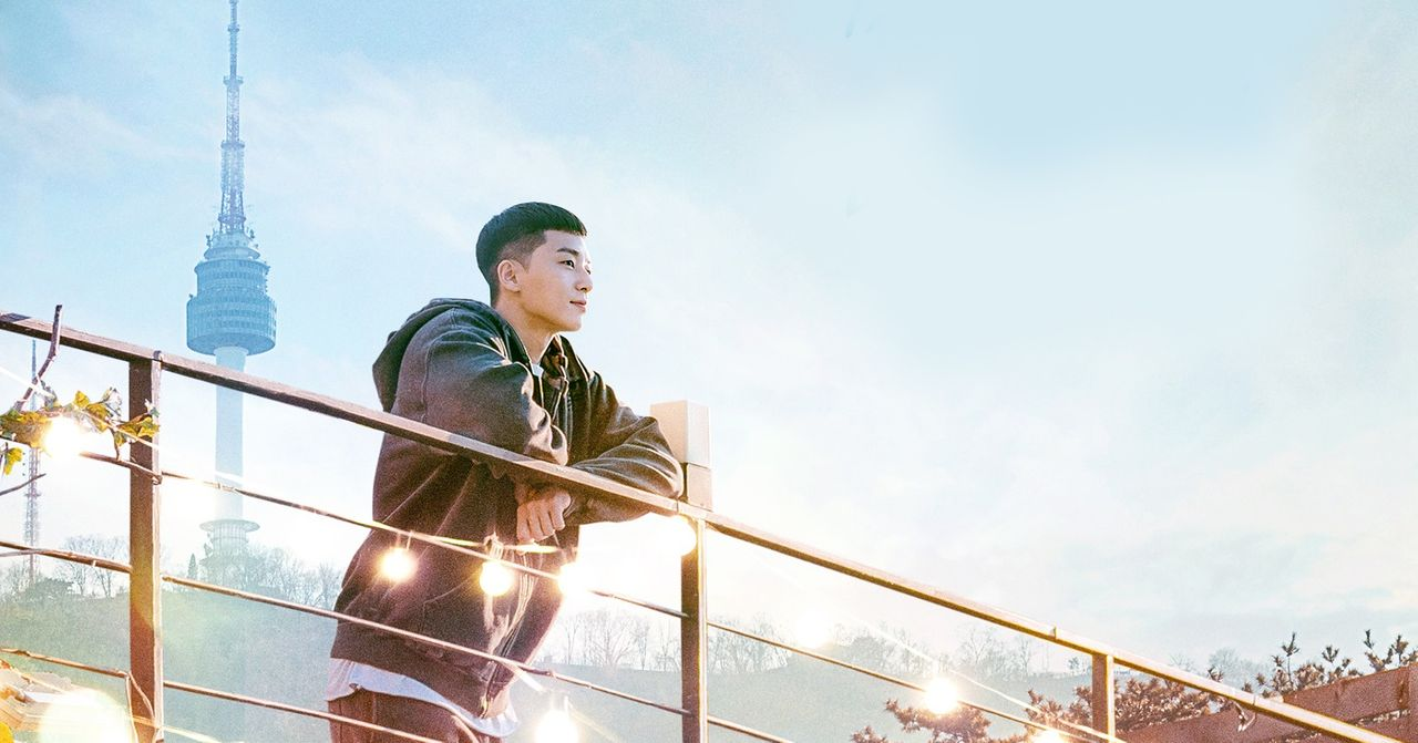 男孩在南山塔前的鞦韆上拍攝，背景有南山塔和藍天