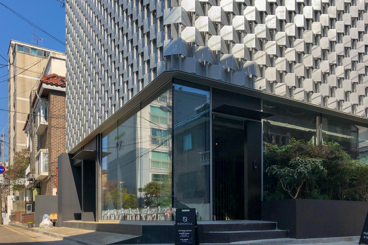 OSECHILL咖啡廳外觀，顯示獨特藝術設計的建築物，與周圍環境和睦共處。