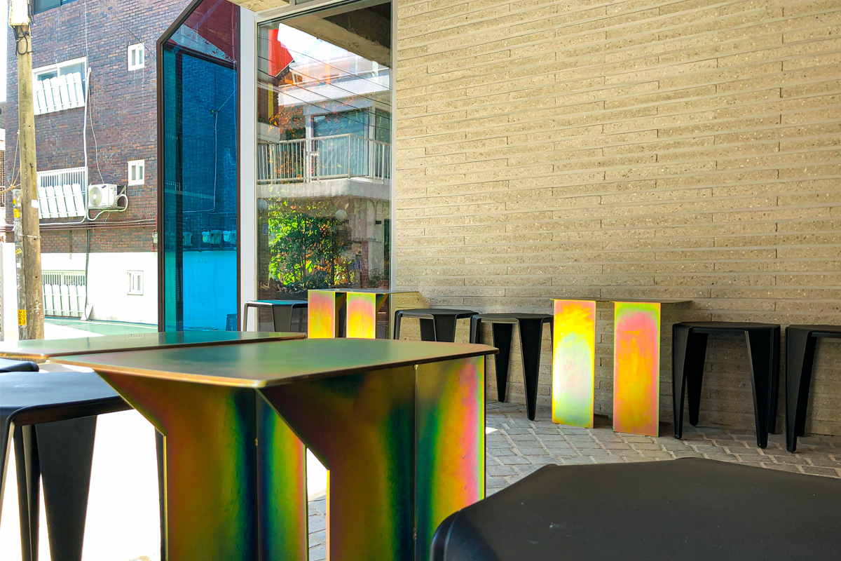 OSECHILL咖啡廳特寫，用彩色漆面打亮的桌椅設計，展示了MINO的個人風格。