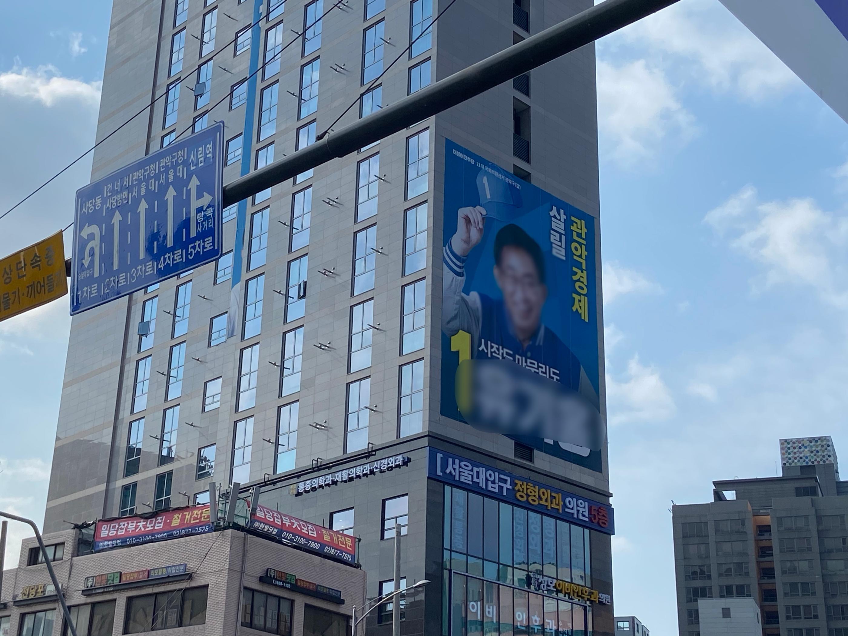 韓國街道上的大型選舉海報，展示了候選人的競選標語。