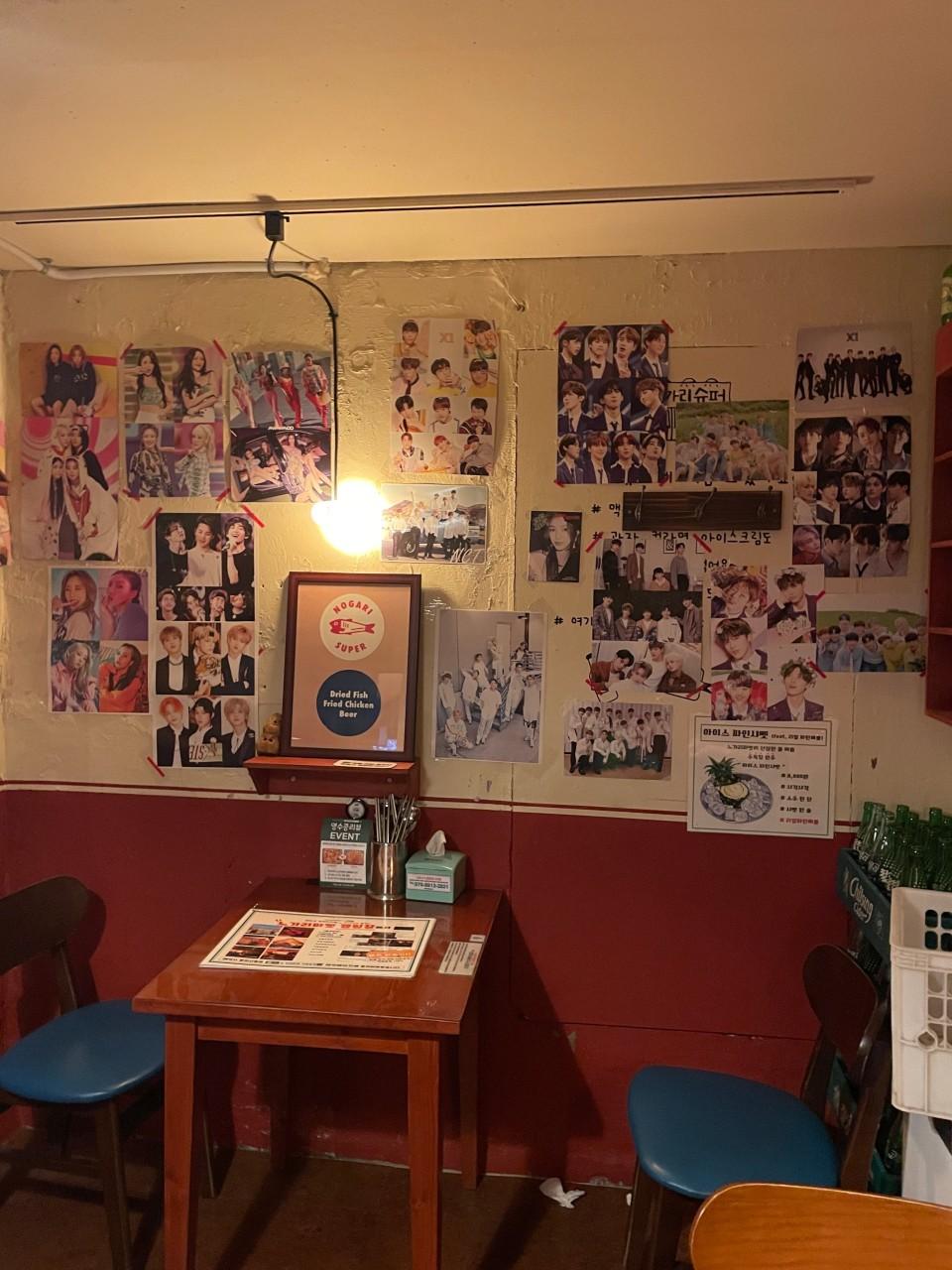 ノガリマーケットの壁に貼られたK-POPグループの写真やポスター。NCTを含むさまざまなアーティストのイメージが飾られている。