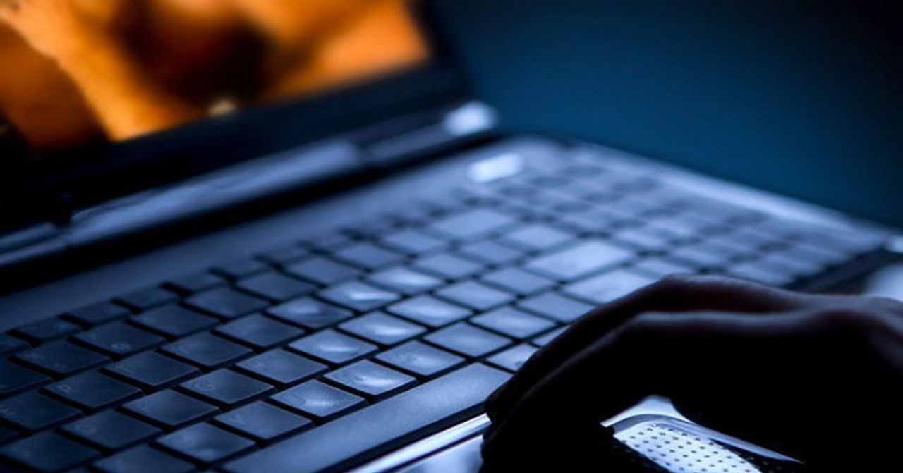 電腦鍵盤上的手，可能涉及兒童色情片的非法下載 或 瀏覽活動。