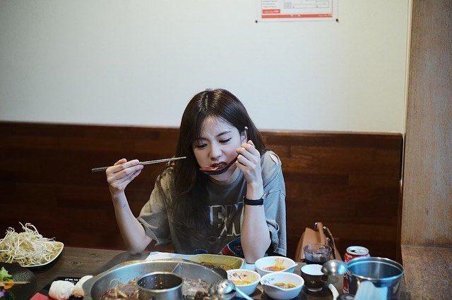 Buliaで楽しめる具材豊富な火鍋の風景で、新鮮な野菜や肉が用意され、テーブルで調理される様子が映し出されています。