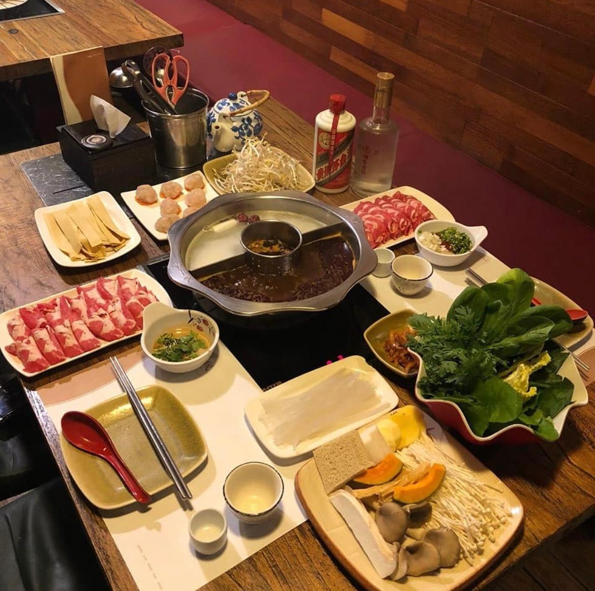 Buliaでの豪華な火鍋セット。新鮮な野菜やきのこ、肉類が綺麗に盛り付けられており、贅沢なディナータイムを演出する。