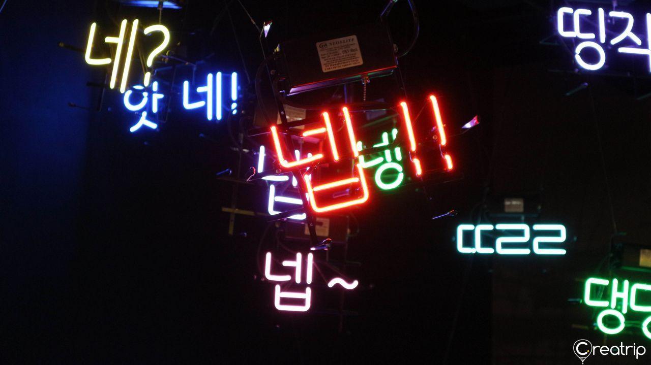 Neon signs with Korean text part of an interactive exhibit area at Kakao Museum.