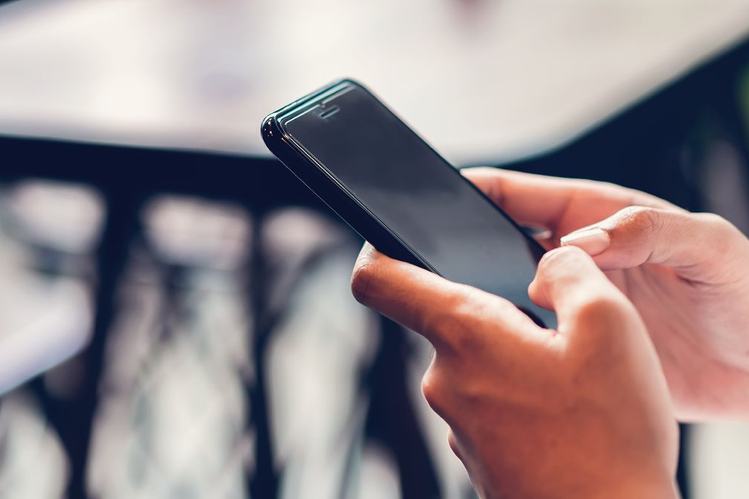 手持智慧型手機的特寫圖，象徵著漁場管理中的溝通方式