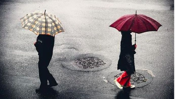 下雨天兩個人用不同的雨傘背對揹走著