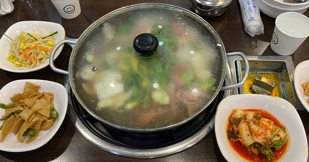 「松炭部隊鍋正準備中，配有各種韓國傳統小菜」