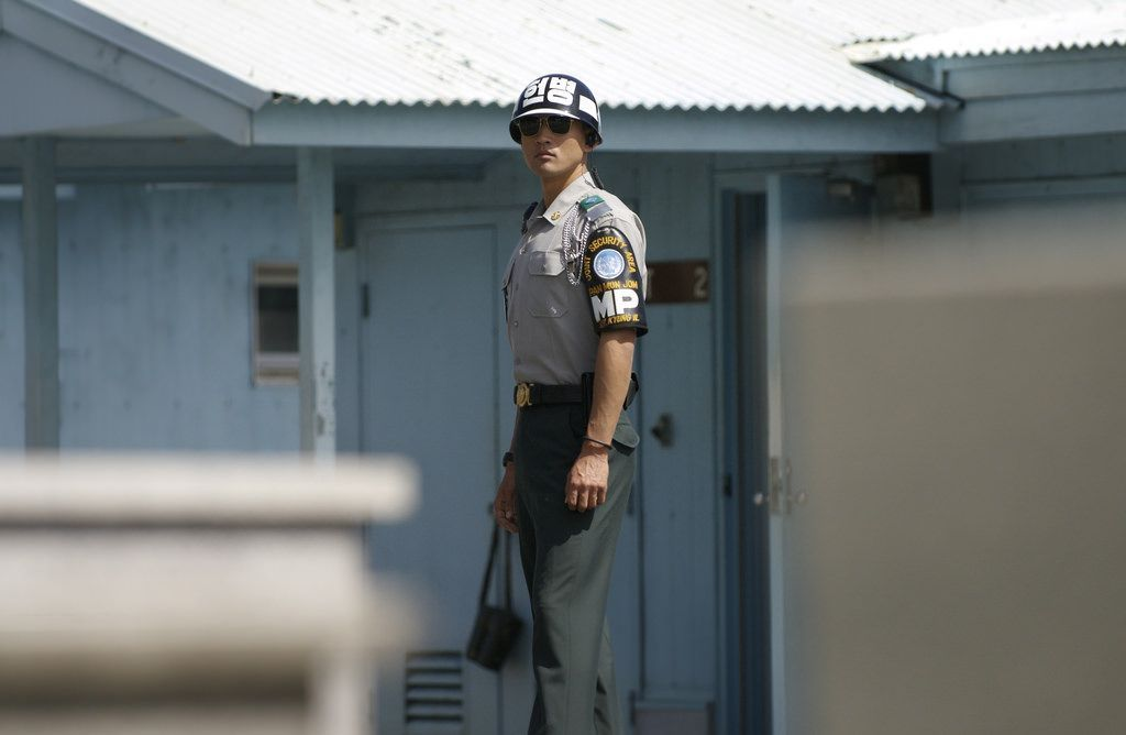 身穿軍服的士兵站在韓朝非武裝地帶（DMZ）的軍事防線旁。