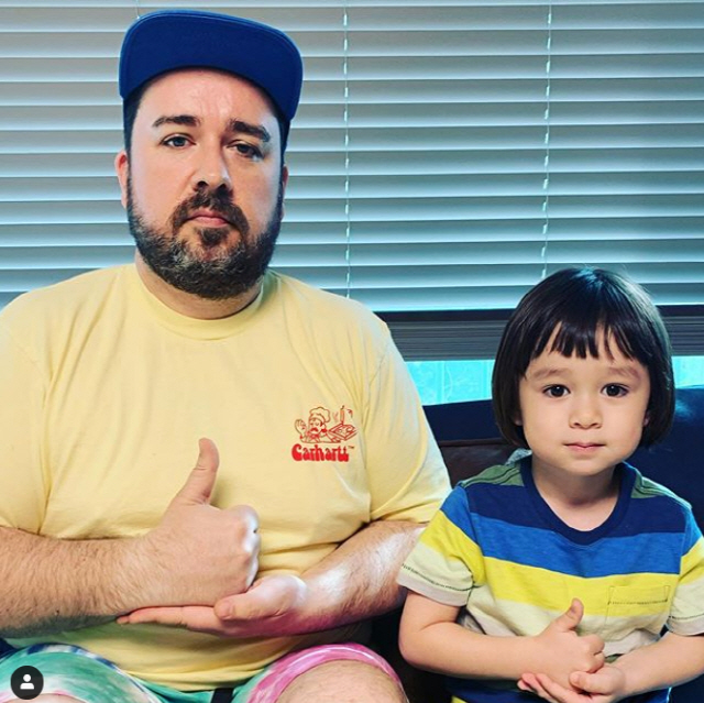 成年的男士和小男孩一起展示感謝手勢，支持韓國醫護人士。