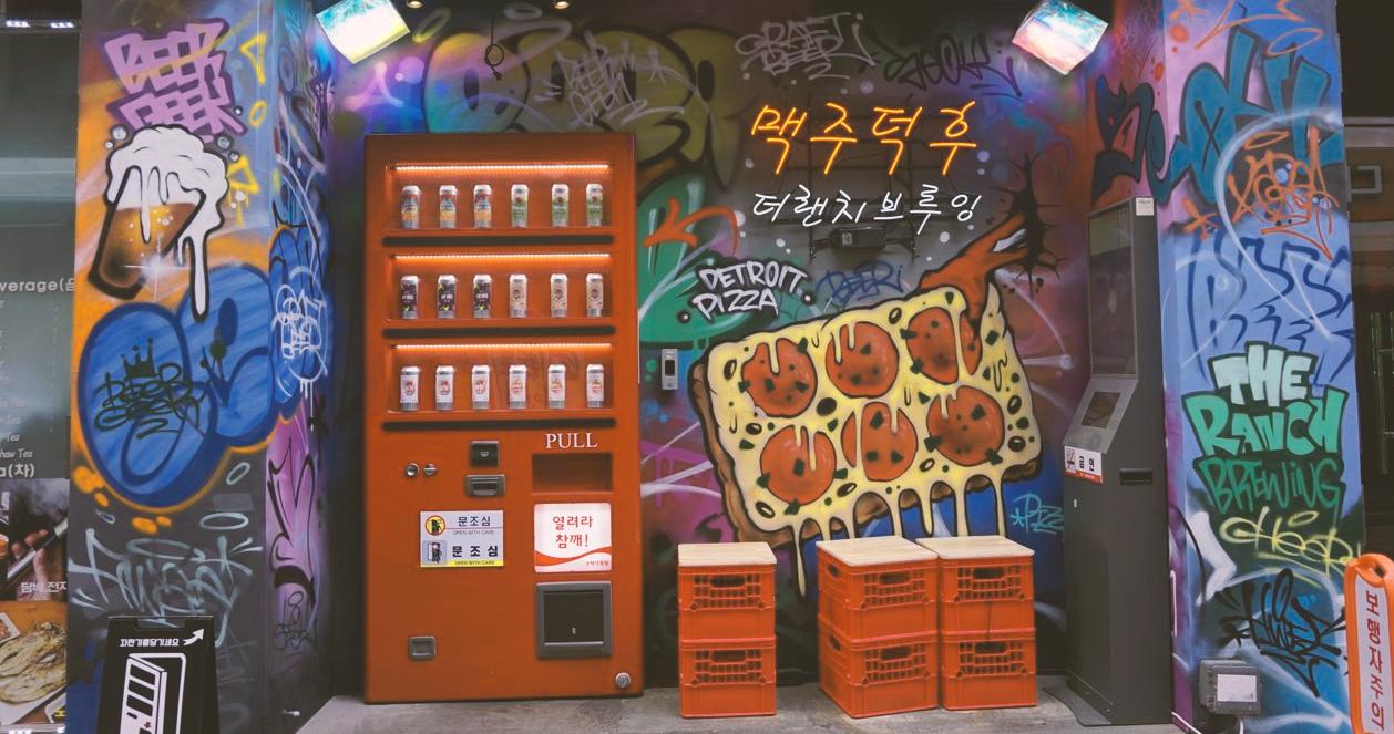 Máy bán hàng tự động màu đỏ và graffiti nghệ thuật tại lối vào của Beer Duckhu x The Ranch Brewing ở Euljiro, Seoul.