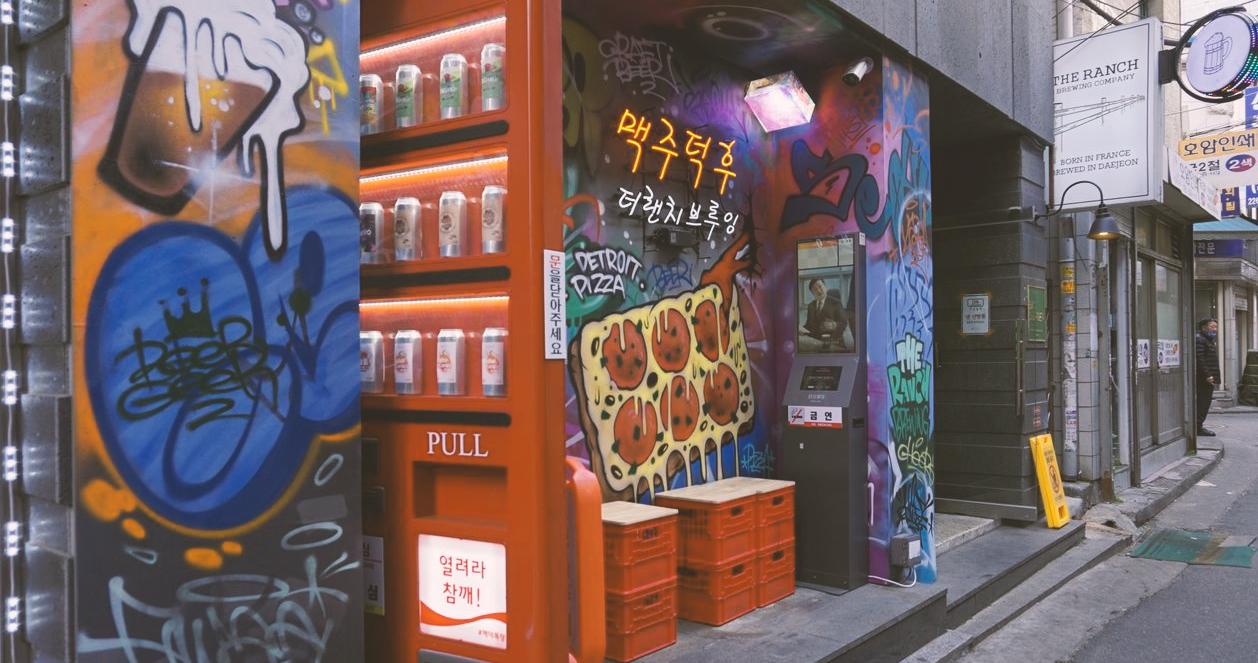 Cảnh góc nghiêng của máy bán hàng tự động và vẽ graffiti tại Beer Duckhu x The Ranch Brewing, nằm sâu trong một con hẻm ở Euljiro, Seoul.