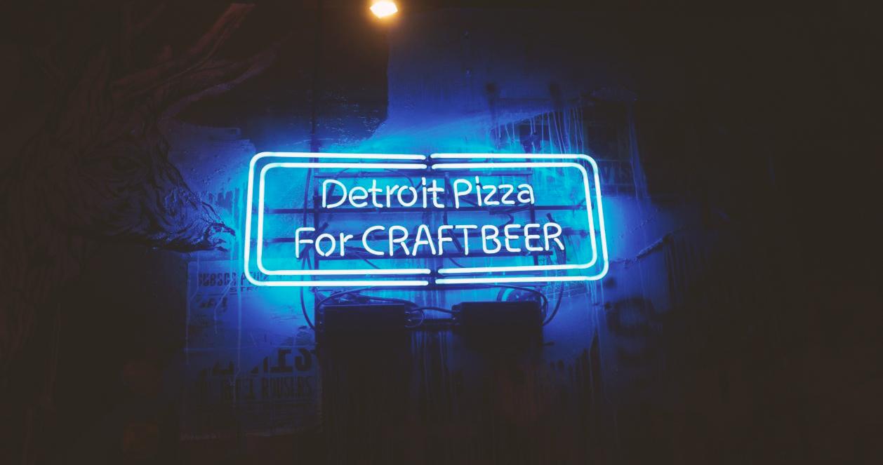 Bảng hiệu neon chiếu sáng với dòng chữ 'Detroit Pizza for Craftbeer' trên tường tại Beer Duckhu x The Ranch Brewing, Euljiro, Seoul.
