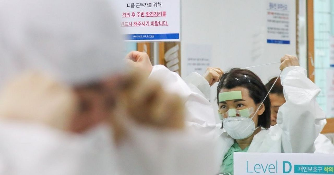 護士正在穿戴個人防護裝備準備為病患者提供檢測服務。