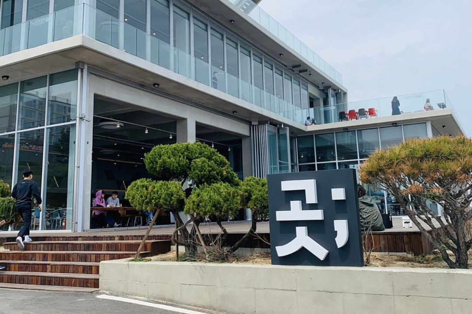 江陵 MAY YOUR HAPPINESS CONTINUE HEREAFTER 咖啡館的外觀,顯示大型玻璃窗及露台設計。