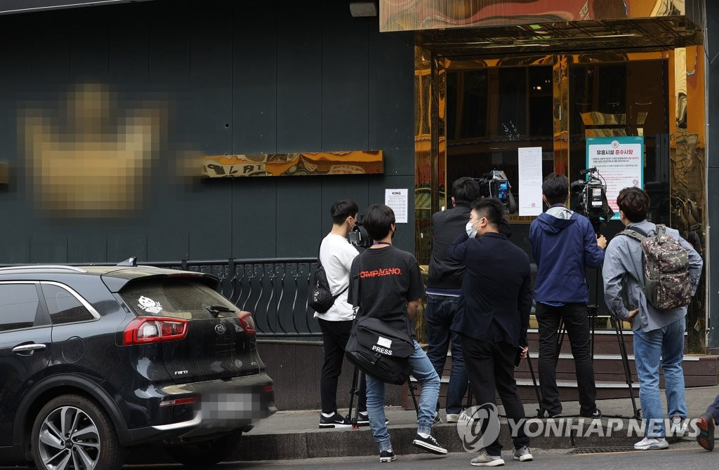 梨泰院夜店外的記者和攝像師正在拍攝關於新冠疫情的新聞。