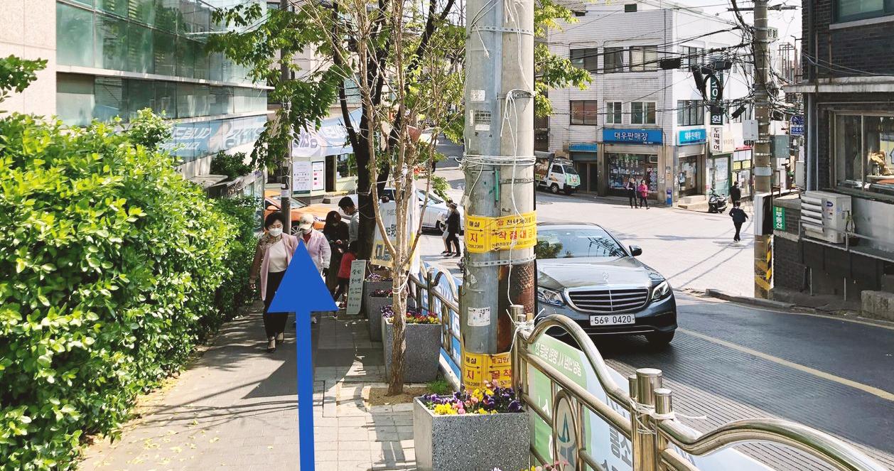 Con đường lát đá nhỏ dẫn lên cầu thang, nằm gần Seven Hair Shop ở khu dân cư Itaewon, Seoul. Đường đi yên tĩnh và mát mẻ với cây cối bao quanh.