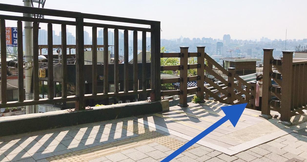 Cầu thang gỗ dẫn lên khu vực cao hơn với tầm nhìn ra toàn cảnh thành phố Seoul, mang lại không khí thư thái và gần gũi với thiên nhiên.