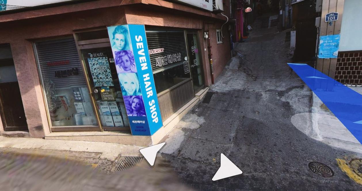 Đường phố nhộn nhịp tại khu vực Itaewon với ô tô đậu hai bên và một taxi đang chạy, cho thấy một ngày nhộn nhịp và đời thường tại Seoul, Hàn Quốc.