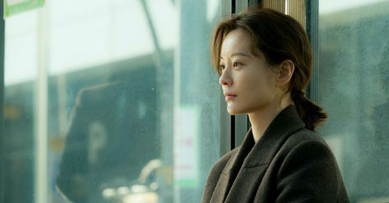 Szene aus dem koreanischen Film 'Kim Ji Young, Geboren 1982'. Eine Frau steht an einer Haltestelle und schaut nach draußen.