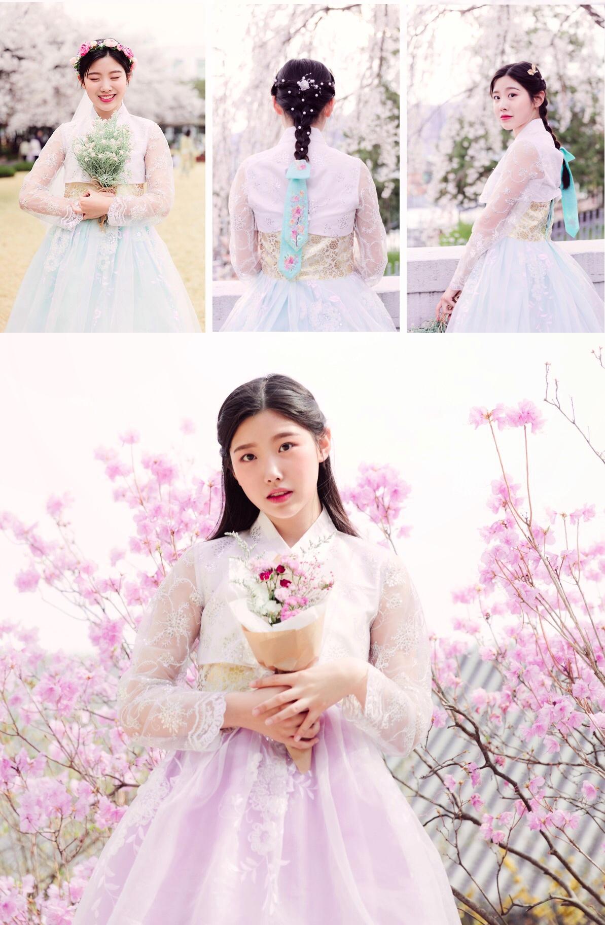 春の桜を背景に、伝統的な韓服を着て花束を持っている姿。