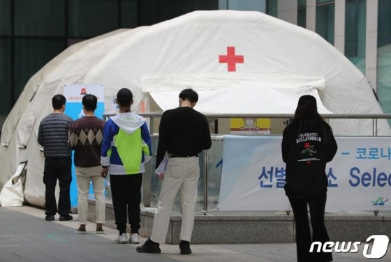 梨泰院COVID-19檢測中心外的市民排隊等候進行篩檢，新冠病毒持續在夜店內擴散之消息。