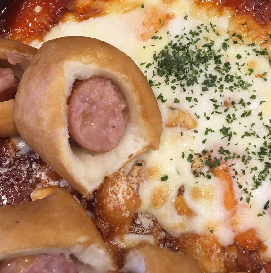 ソーセージ味の韓国式トッポッキのホットドッグにチーズが絡んだクローズアップ画像