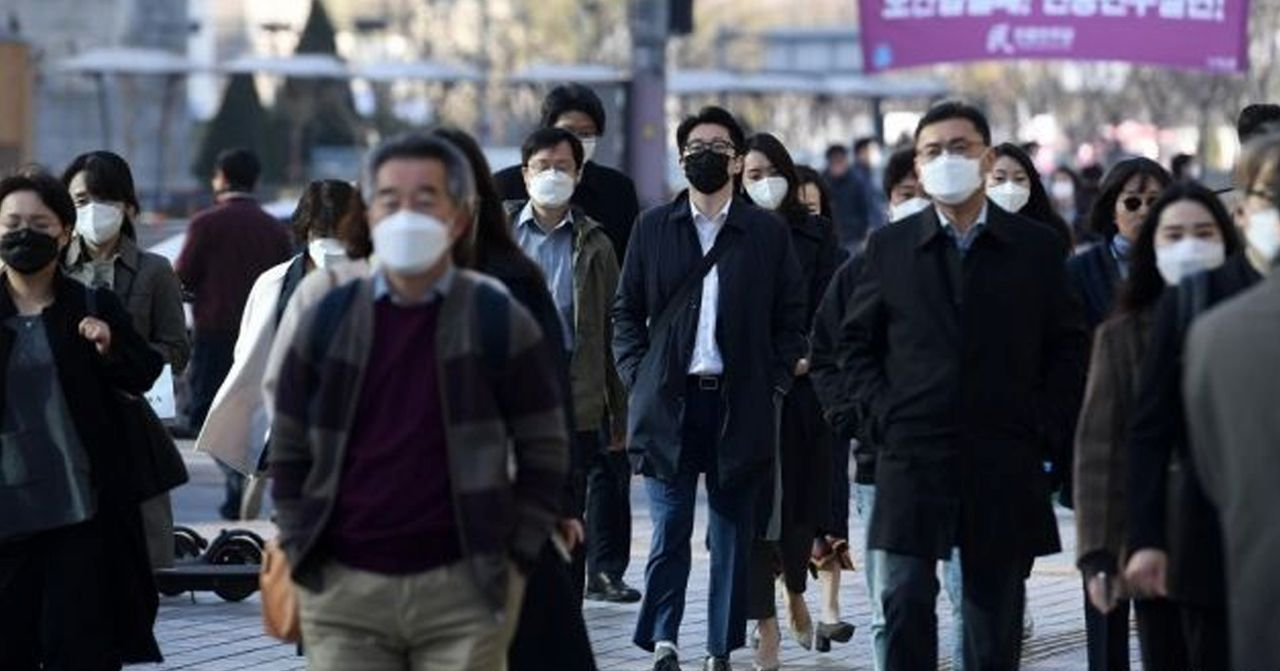 韓國首爾街上出現戴口罩的行人，反映出新冠疫情期間民眾的防疫措施和日常生活。