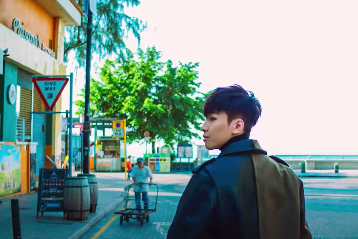 香港赤柱街道上的户外餐廳前行走的年輕人，背景是一名長者推籃