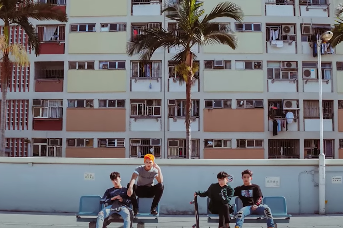 香港彩虹村內的椰樹前面擺放輕鬆姿態的年輕人羣組