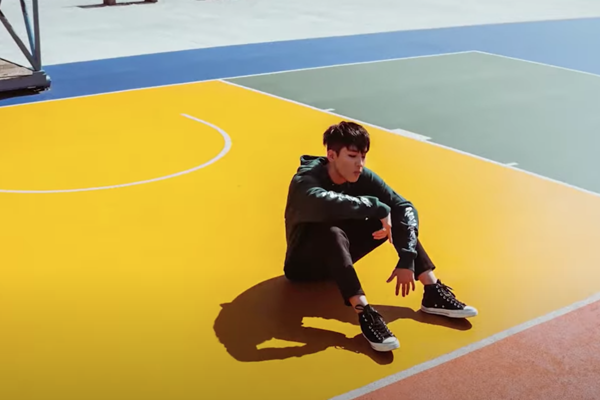 彩虹村籃球場，一位年輕人在色彩鮮艷的球場一角靜坐