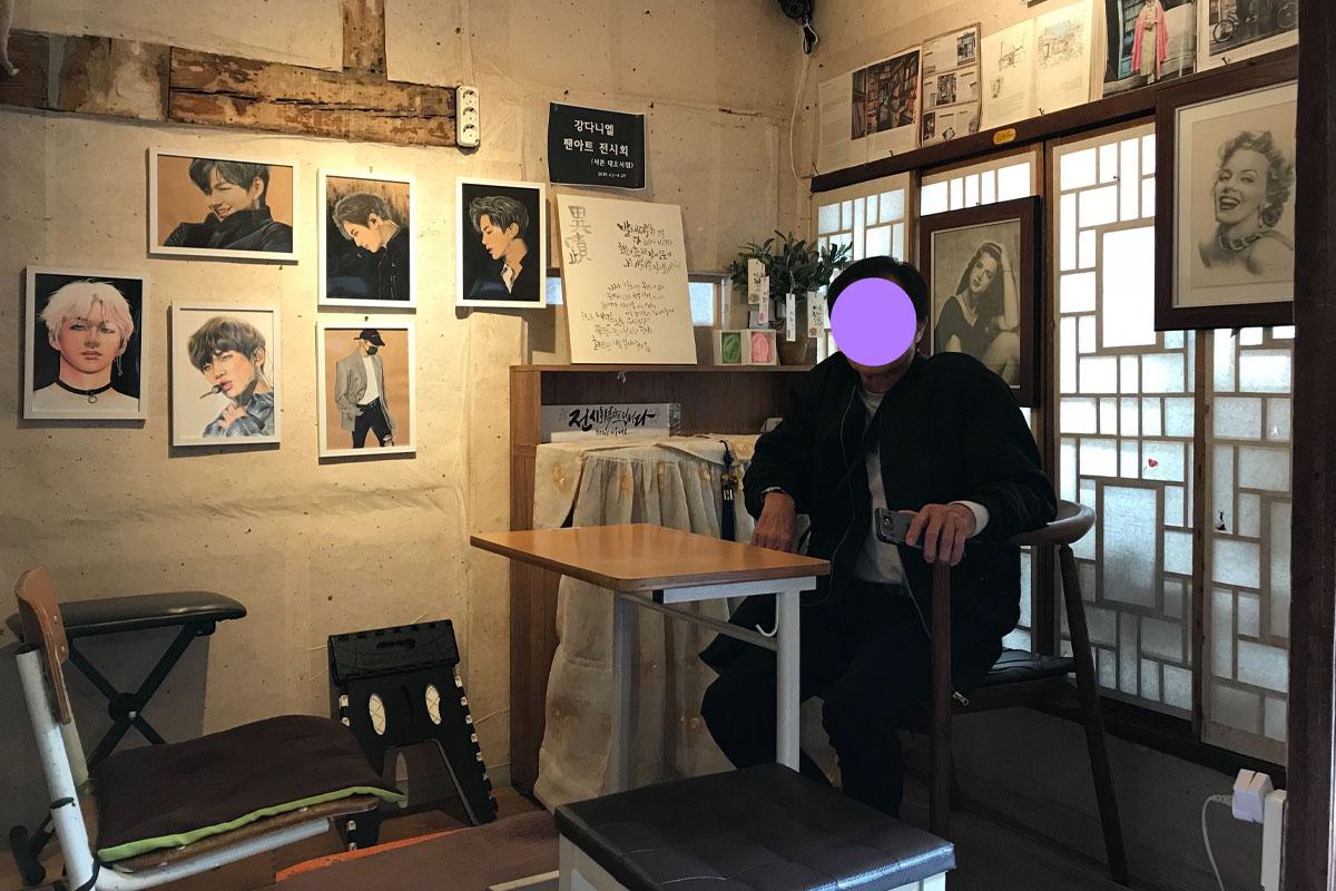 มุมในแดโอ ซอจอม คาเฟ่ที่มีโต๊ะและเก้าอี้เรียงราย ธีมศิลปะในร้านให้ความรู้สึกอบอุ่น