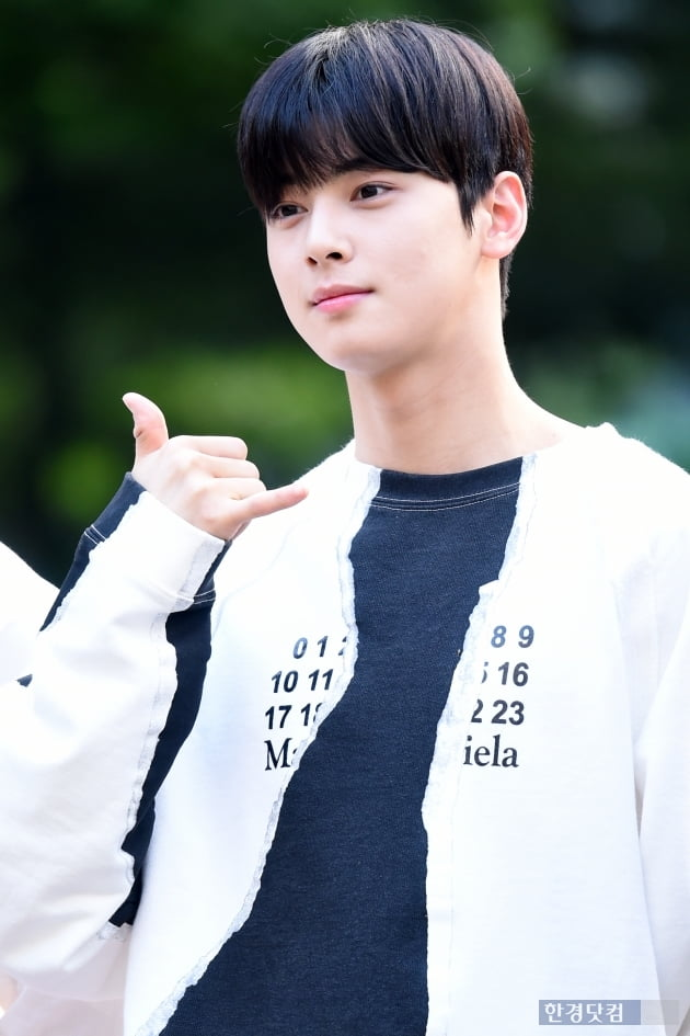 韓國男偶像成員在戶外活動中穿著黑白色拼接上衣的拍攝照片。