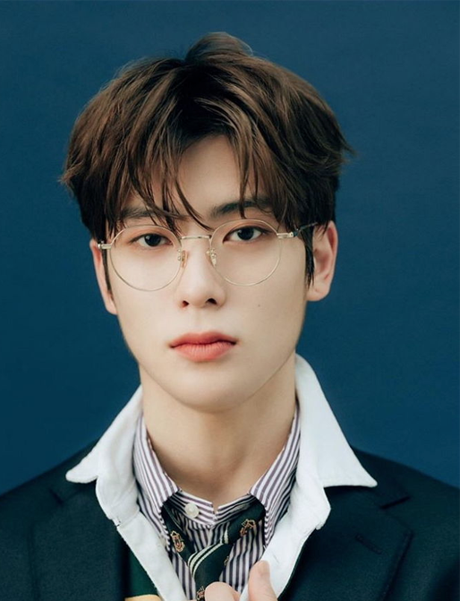 韓國男子偶像組合成員穿著西裝的造型照片，背景為藍色。