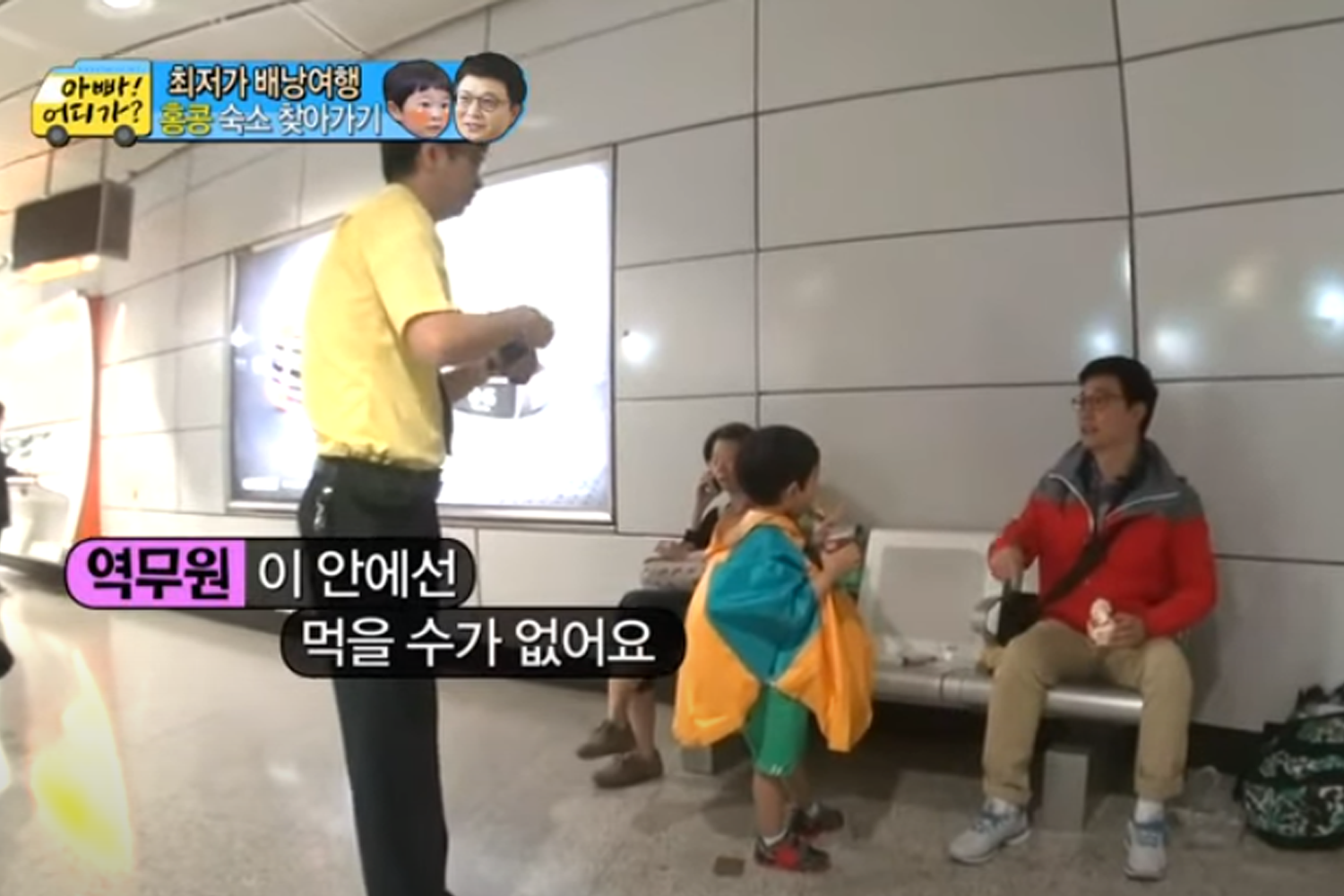 乘客在地鐵站內的長椅上飲食，旁邊有一位工作人員提醒的場景，展示了地鐵站內禁止飲食的實際情況。