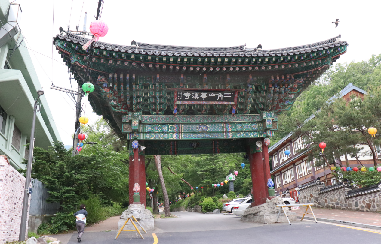 Gerbang Buddha yang khusyuk menjaga pintu masuk Kuil Hwagyesa, memberikan suasana menghormat dan damai.