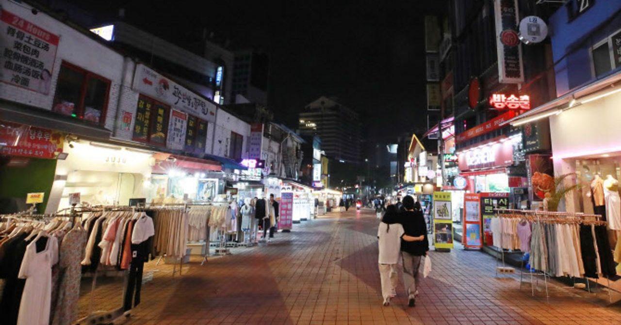 夜間韓國街頭商店林立，街道上的行人稀少，反映疫情期間夜生活的影響。