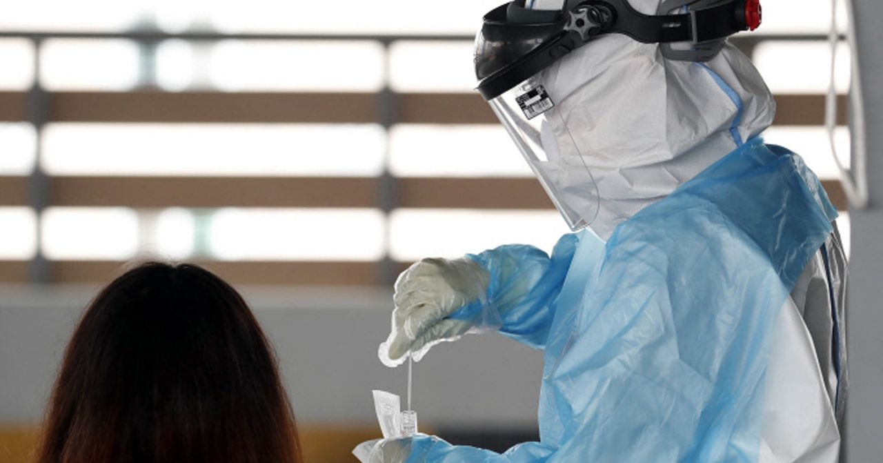 醫護人員身穿防護服進行COVID-19檢測。