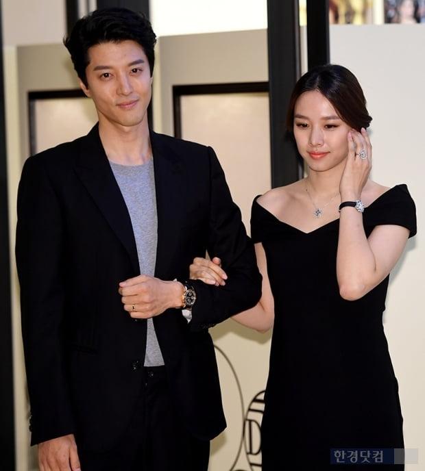 ブラックドレスを着たチョ・ユニとスーツ姿のイ・ドンゴン、カメラに向かってポーズをとっている