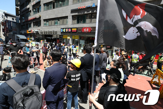 韩国首尔，中国驻韩大使馆附近，抗议者持黑色旗帜，反对香港《国安法》的集会场景