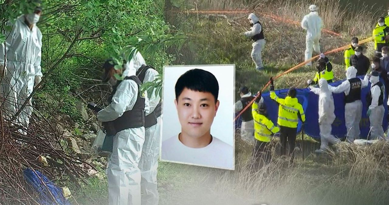 การสืบสวนบริเวณป่าที่มีผู้สวมชุดป้องกันกำลังตรวจสอบหลักฐานต่าง ๆ บริเวณนั้น