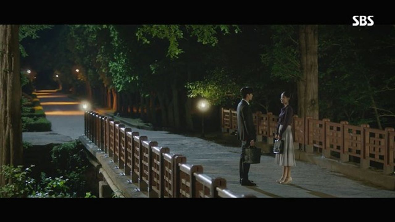 韩剧《死的赞美》拍摄场景，展示了一个浪漫的夜晚桥梁场景，背景灯光柔和。